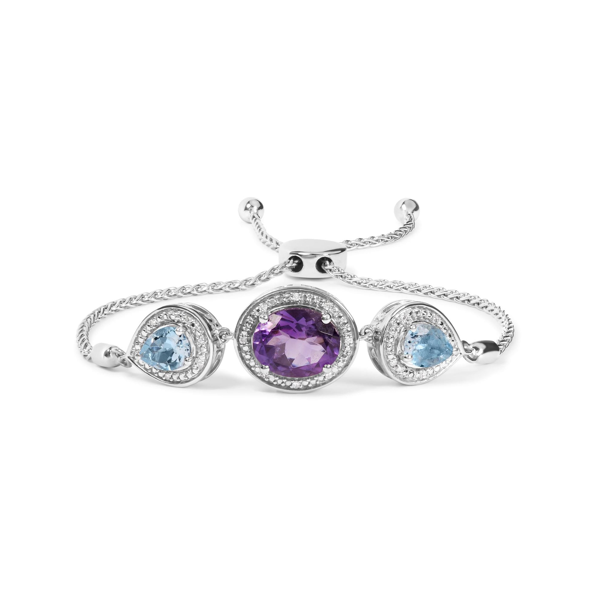 White bracelet with a central oval purple gemstone and two pear-shaped blue gemstones on either side, all surrounded by small round white gemstones, shown in a front-facing angle.
