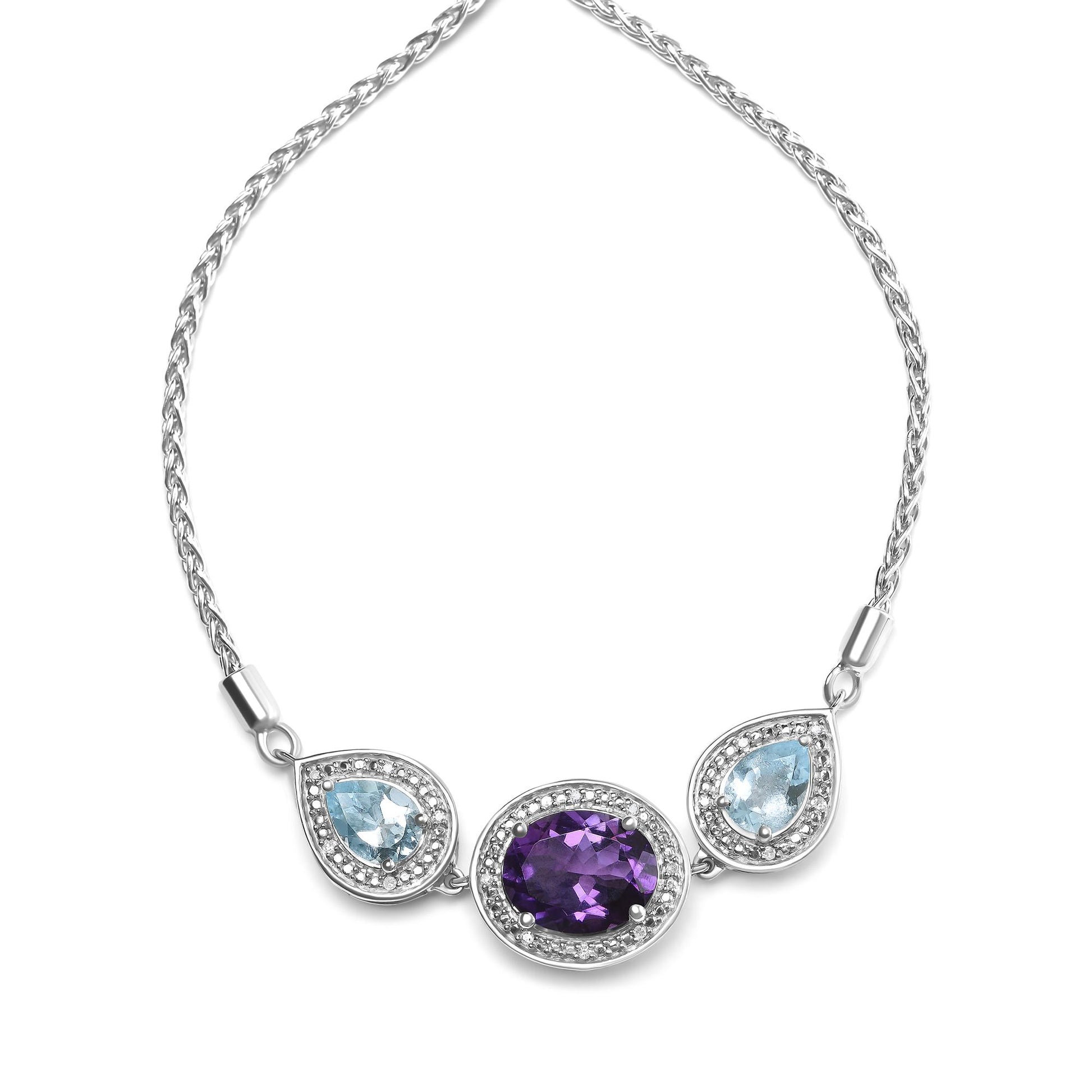 White metal bracelet with a central oval purple gemstone and two pear-shaped blue gemstones on either side, each surrounded by small round white gemstones, shown in a flat lay front angle.