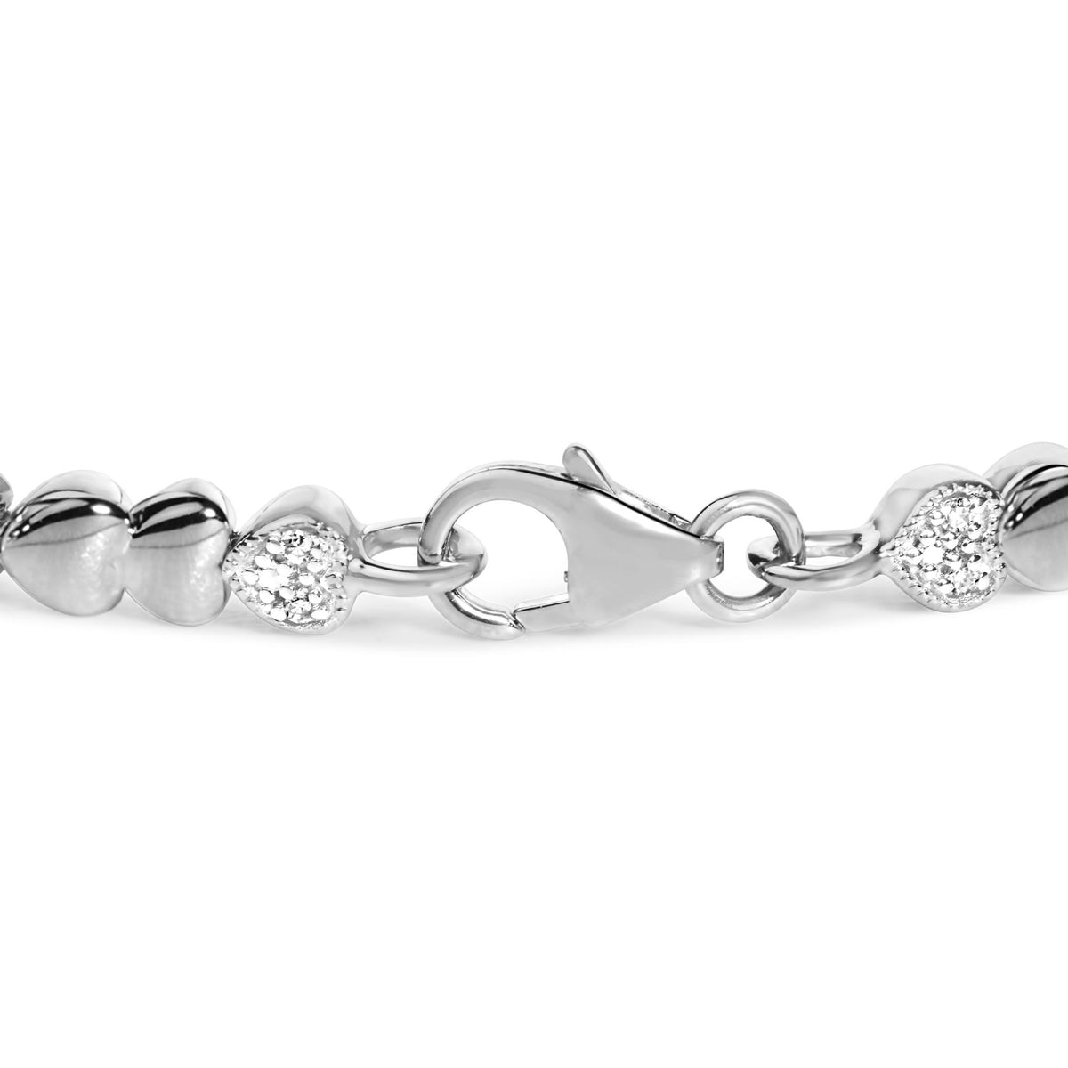 Close-up front angle of a white metal bracelet with heart-shaped links, some set with round white gemstones in pave setting, showing the clasp.