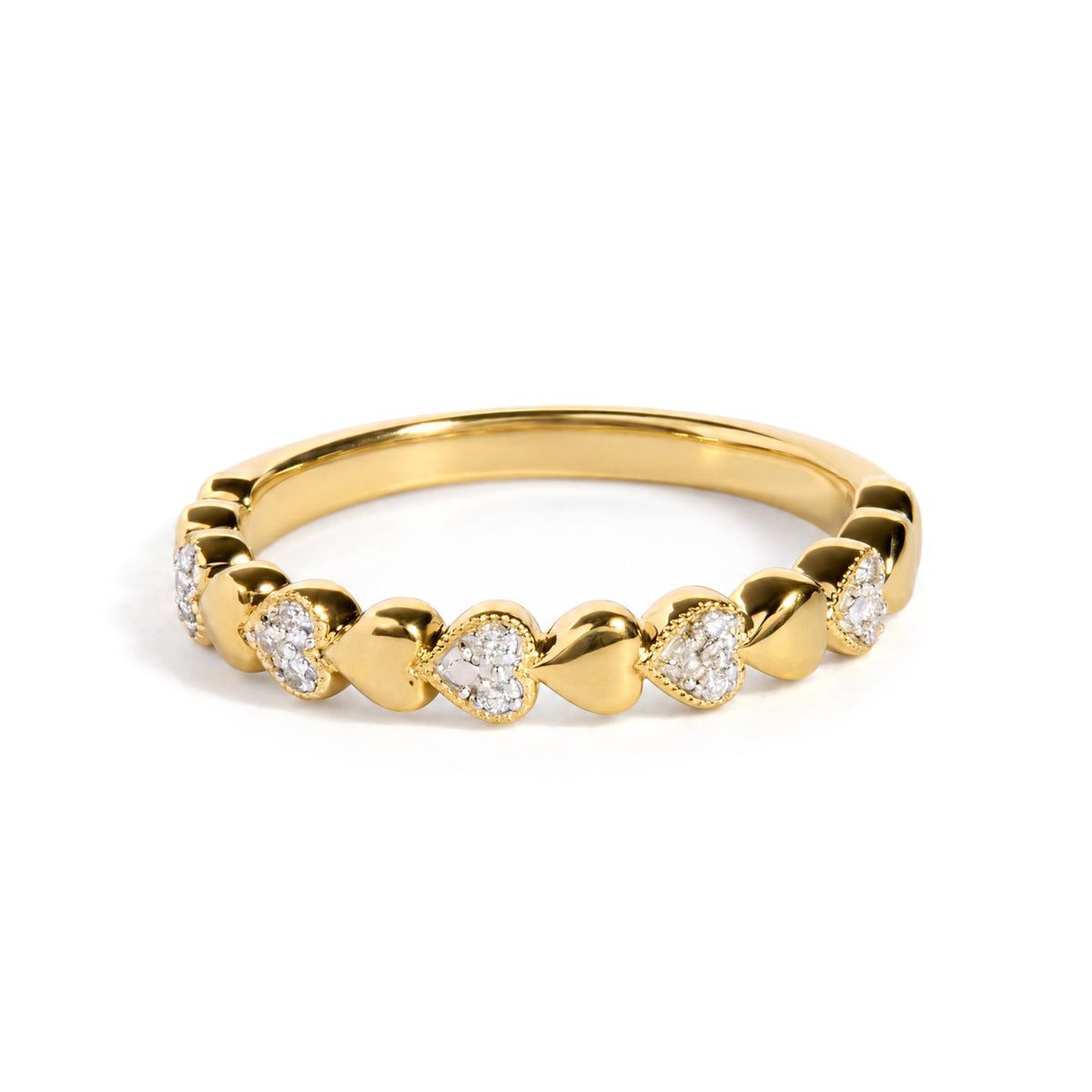 Close-up front angle of a yellow metal ring featuring a row of heart shapes, each containing white gemstones in a pave setting.