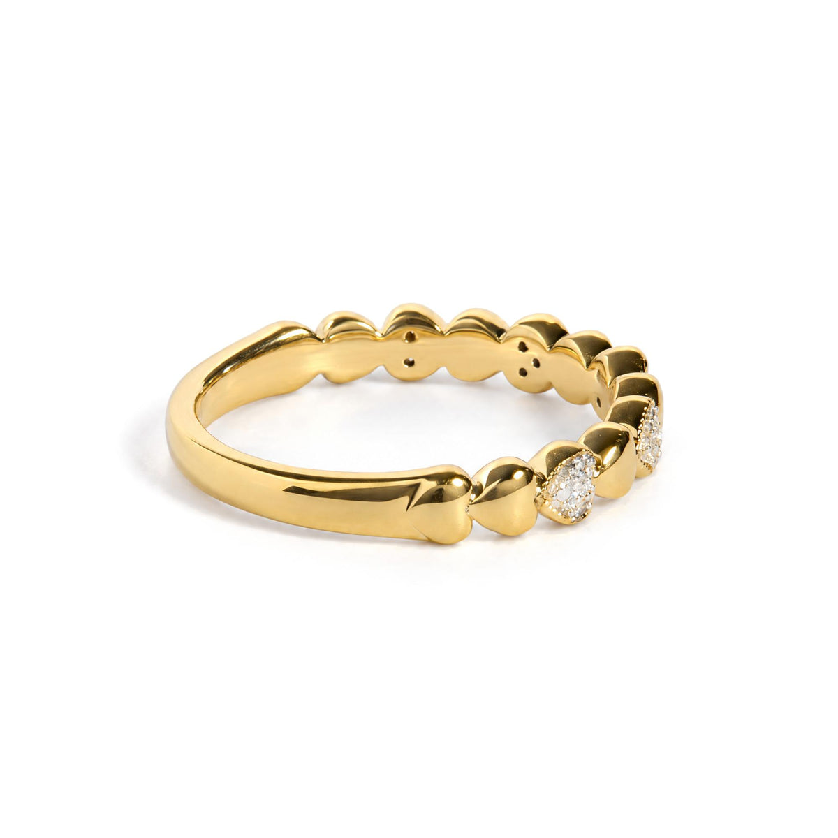 Close-up angled shot of a yellow metal ring with a scalloped design, featuring clusters of small white gemstones in a pave setting.