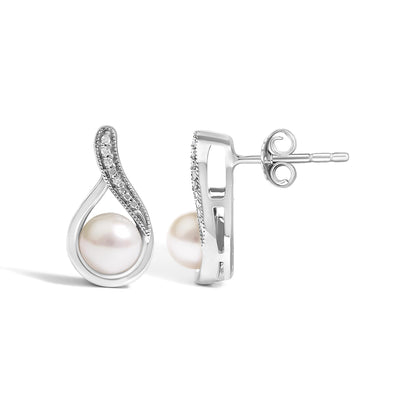 Close-up side and front angle of a pair of white metal earrings with a pearl centerpiece and a curved section adorned with small white gemstones in pave setting.
