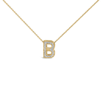 Close-up front view of a yellow metal necklace with a pendant shaped like the letter B, outlined with round white gemstones in prong settings, shown on a white background.