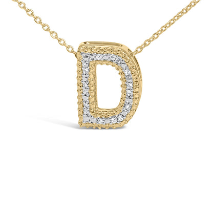 Close-up front view of a yellow metal necklace pendant in the shape of the letter D, outlined with small white gemstones in prong settings.
