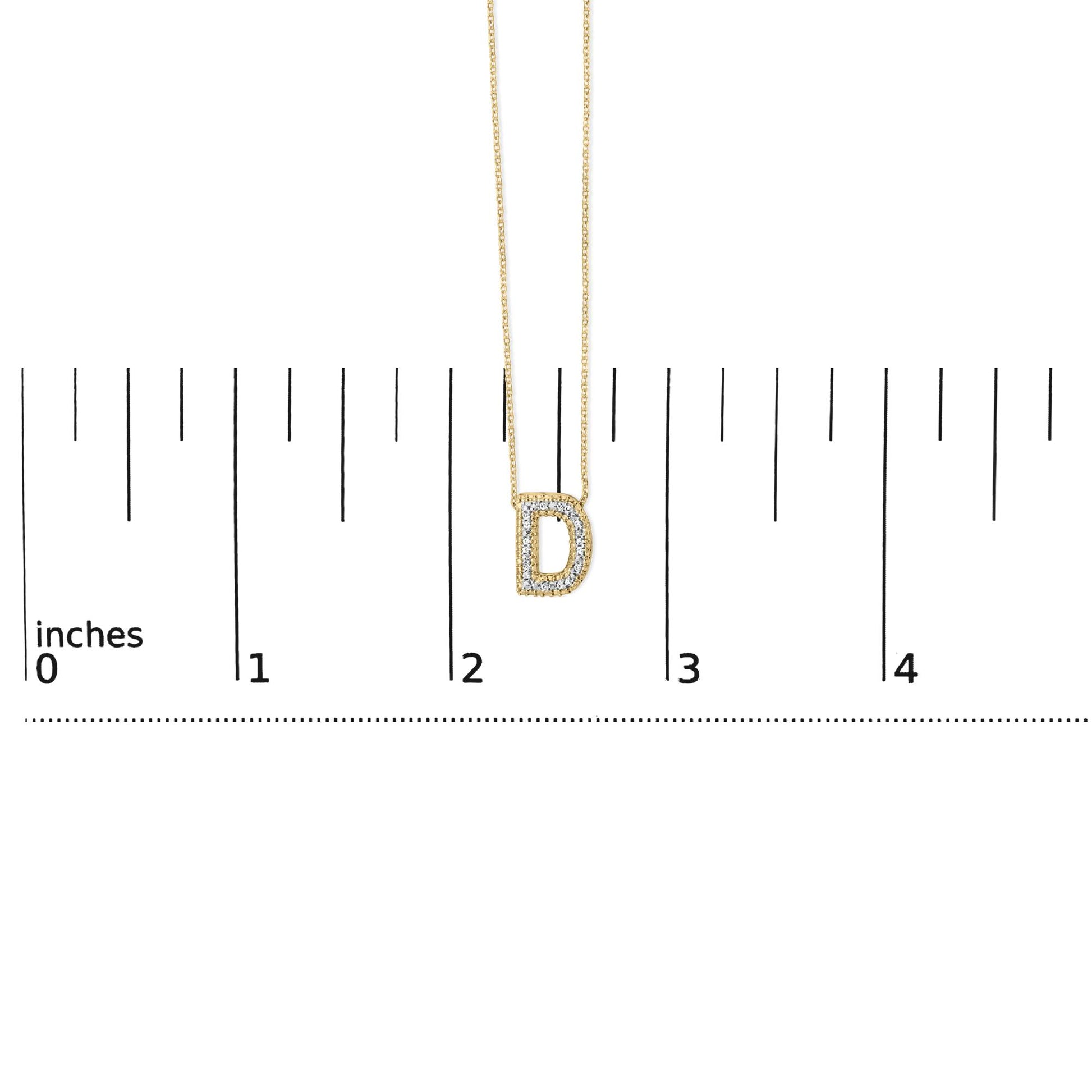 Close-up front view of a yellow necklace with a D-shaped pendant outlined with white gemstones, shown on a scale.