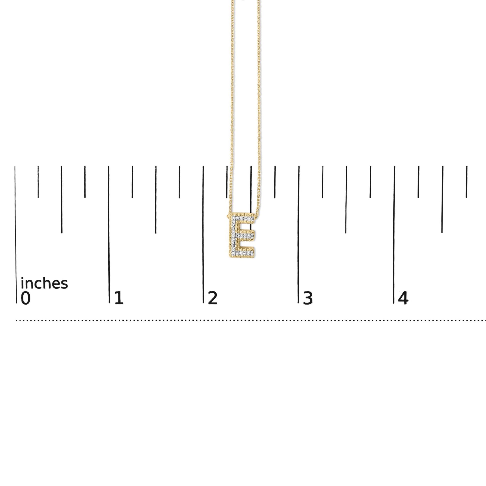 Close-up front view of a yellow necklace with an 'E' pendant encrusted with white gemstones, shown on a measurement scale.