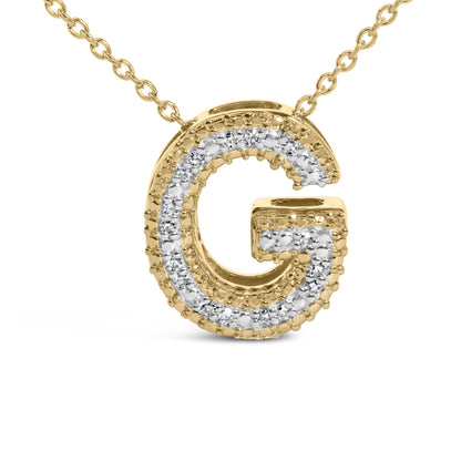 Close-up front view of a yellow metal necklace pendant shaped like the letter G, featuring a row of white gemstones in a prong setting along its edges.
