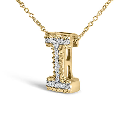 Close-up front angle of a yellow metal necklace pendant in the shape of the letter 'L,' adorned with multiple white gemstones in prong settings along the front surface.