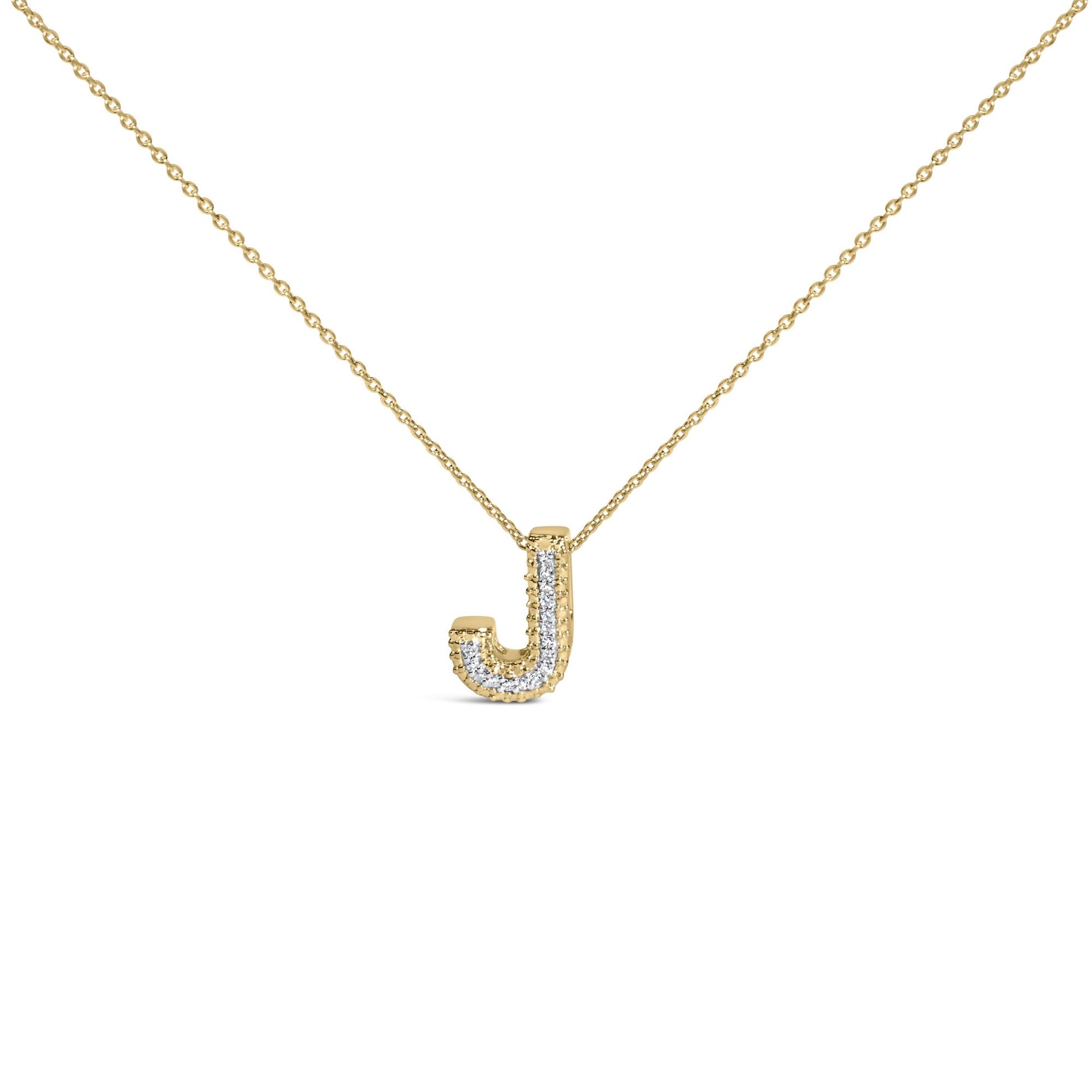 Close-up front angle of a yellow metal necklace with a pendant shaped like the letter J, featuring a row of white gemstones set in prongs along the pendant.