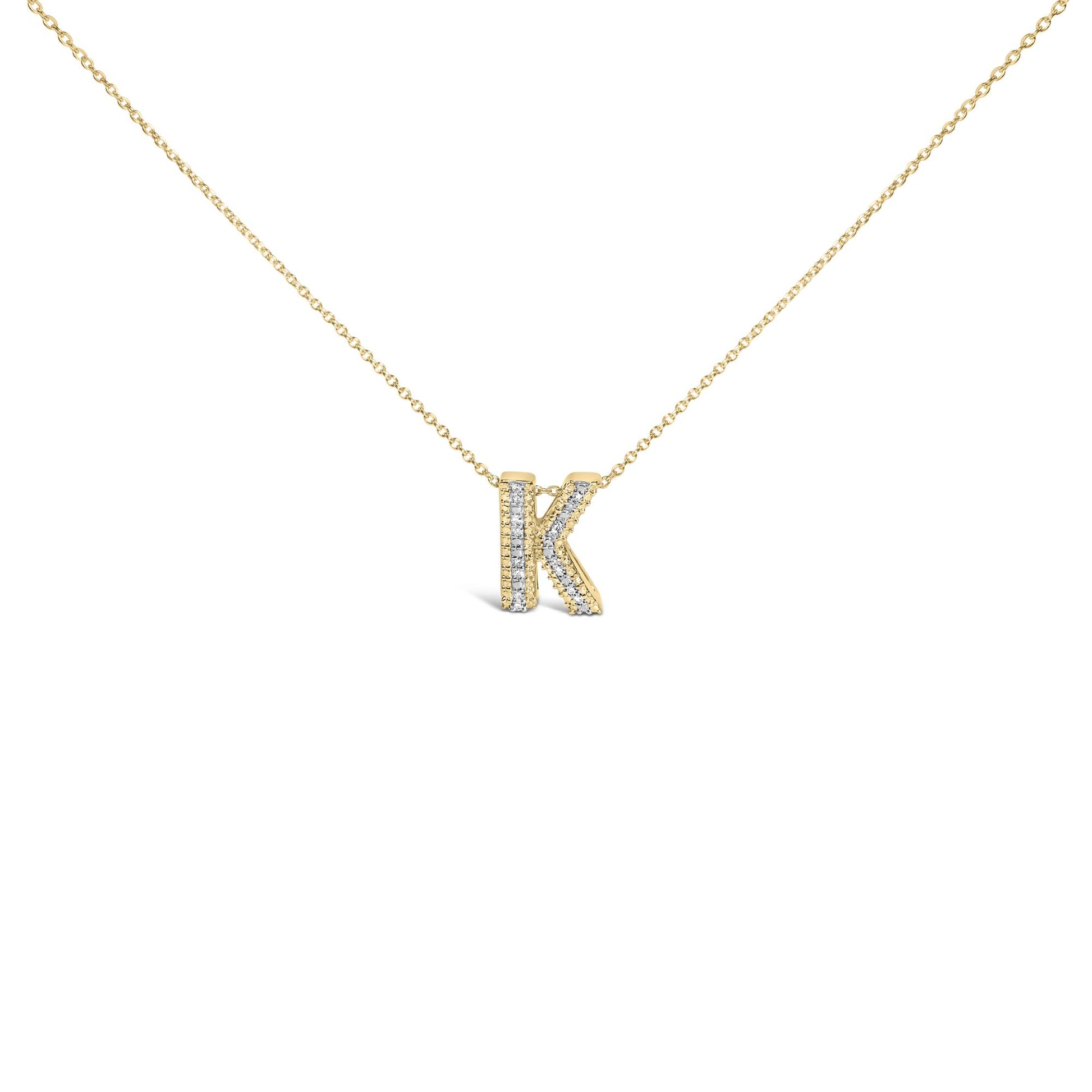 Close-up front angle of a yellow metal necklace with a pendant shaped like the letter K, adorned with round white gemstones in a prong setting on the pendant's front surface.