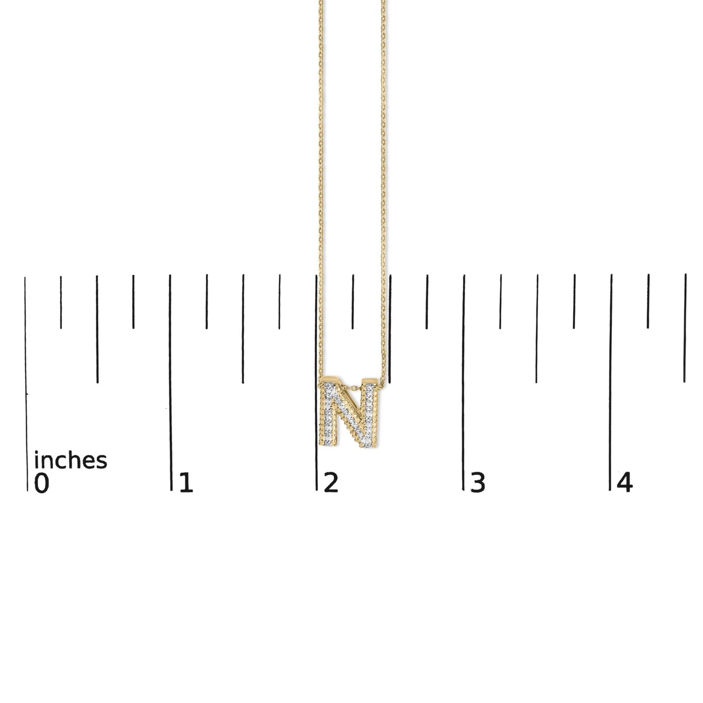 Close-up front view of a yellow necklace with a pendant shaped as the letter 'N' paved with white gemstones, shown on a measurement scale.