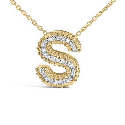 Close-up front view of a yellow metal necklace pendant in the shape of the letter 'S' accented with white round gemstones in prong settings.