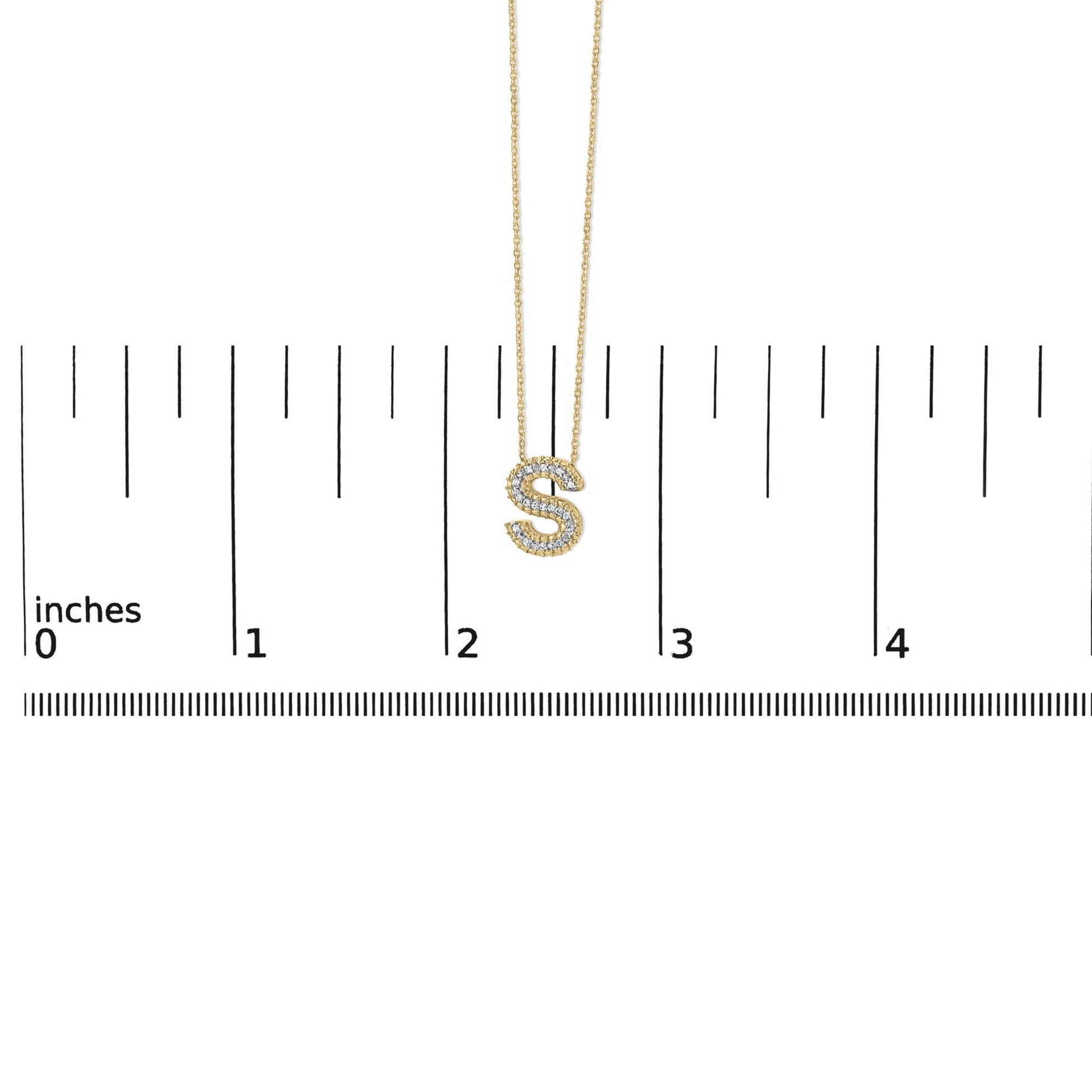 Yellow necklace with an 'S' pendant outlined in white gemstones, shown on a scale from a front angle.