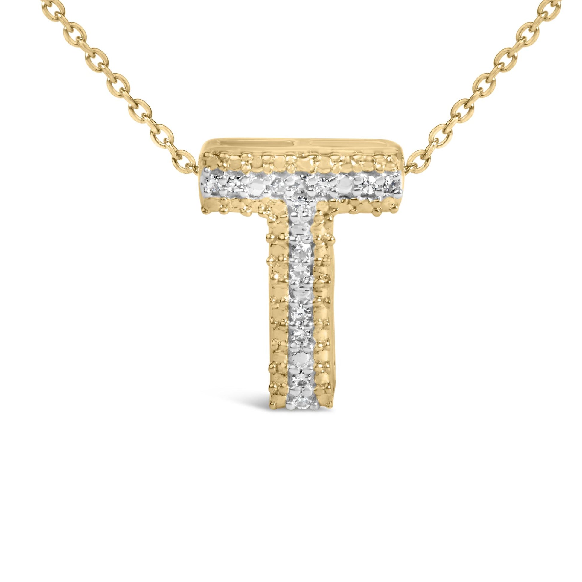 Close-up front view of a yellow necklace pendant in the shape of the letter T, adorned with a vertical and horizontal line of white round gemstones in prong settings, shown on a white background.