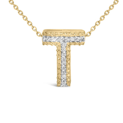 Close-up front view of a yellow necklace pendant in the shape of the letter T, adorned with a vertical and horizontal line of white round gemstones in prong settings, shown on a white background.