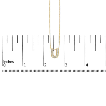 Yellow necklace with a U-shaped pendant adorned with white gemstones in a prong setting, shown on a scale from a front angle.