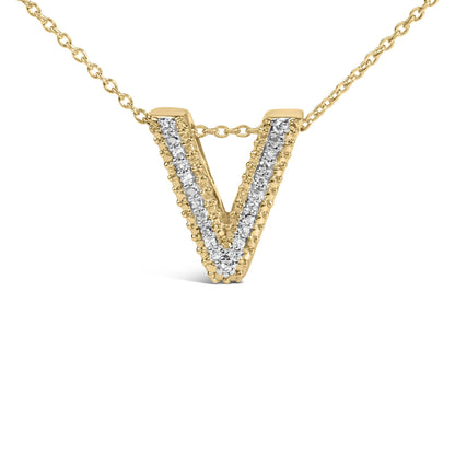 Close-up front angle of a yellow metal necklace pendant in the shape of a letter V, adorned with a row of white round gemstones set in prongs down the center.