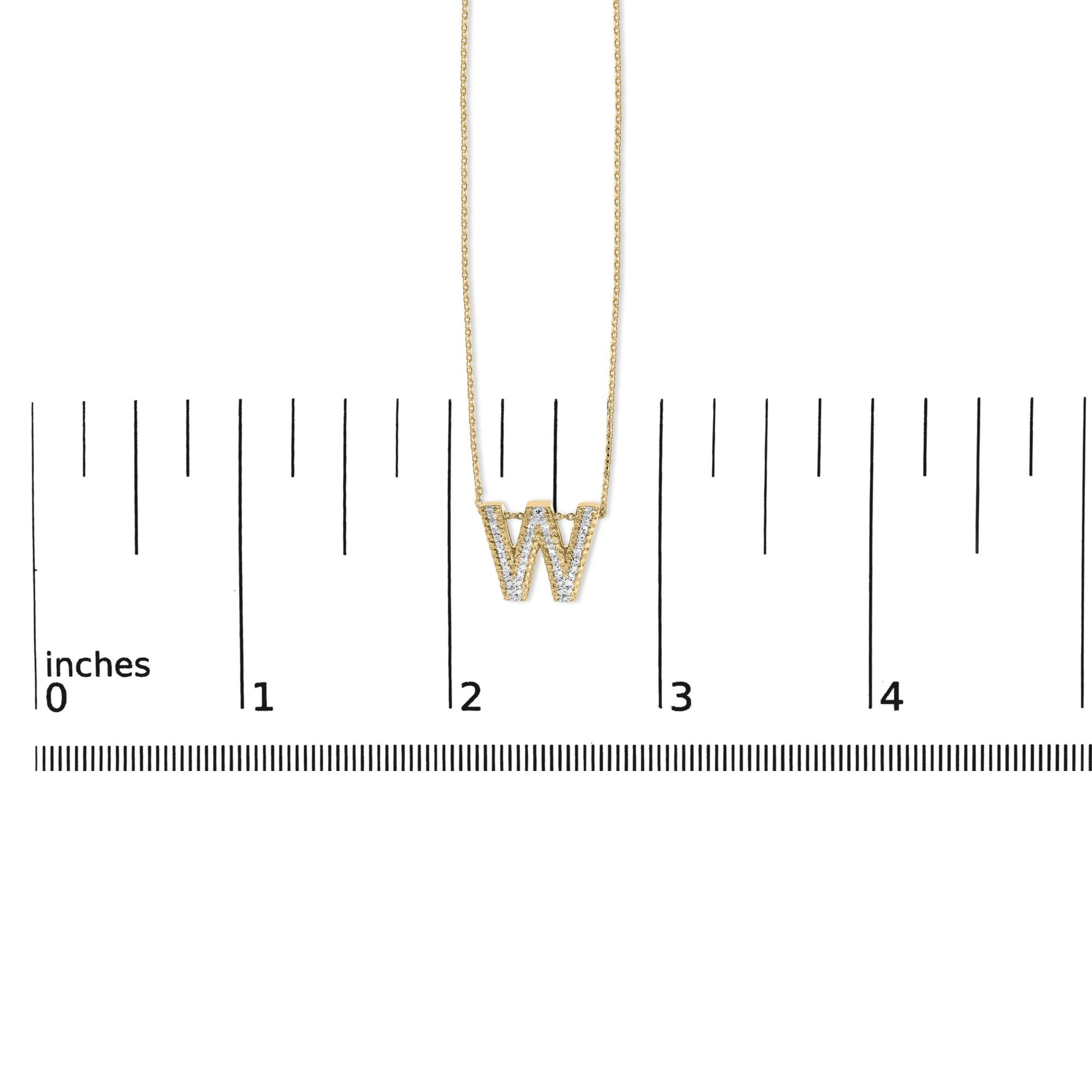 Yellow necklace with a pendant shaped as the letter W, featuring white gemstones in prong setting, shown on a scale from top front angle.