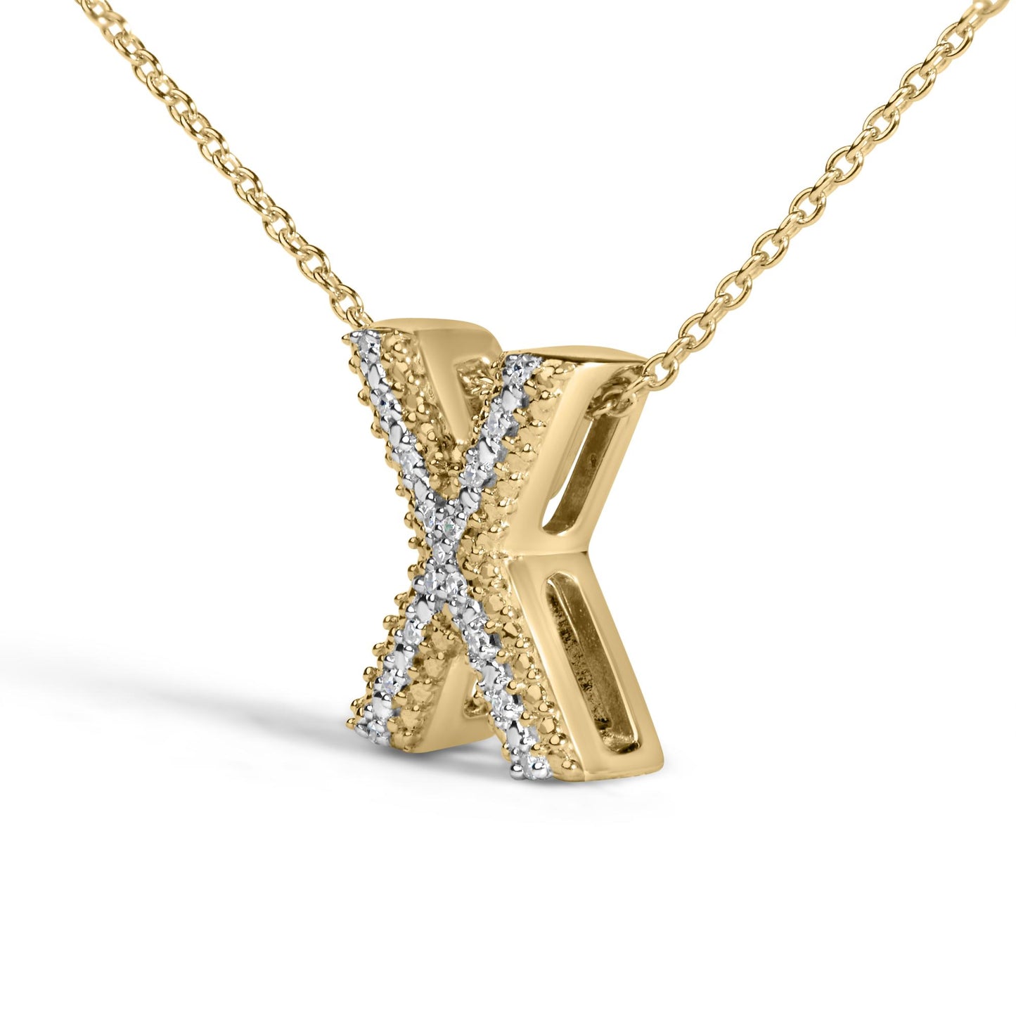 Close-up front angle of a yellow metal necklace pendant in the shape of the letter X, adorned with white round gemstones in prong settings along the center.