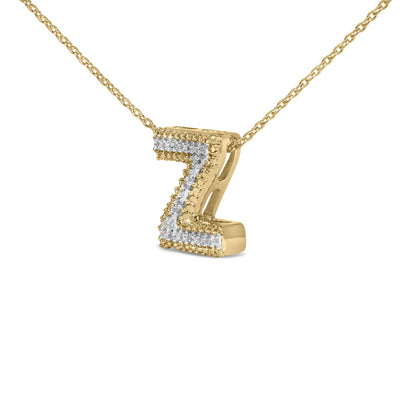 Close-up front angle of a yellow necklace chain with a letter Z pendant outlined with small round white gemstones in prong settings.