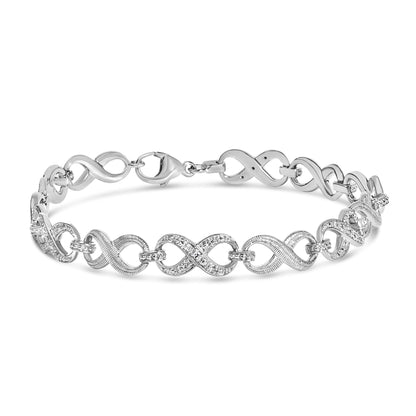 Close-up front view of a white metal bracelet with alternating smooth and pave-set sections featuring round white gemstones, shown on a white background.