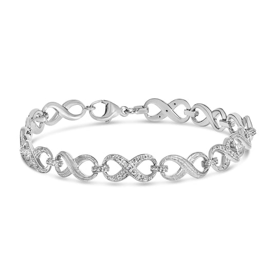 Close-up front view of a white metal bracelet with alternating smooth and pave-set sections featuring round white gemstones, shown on a white background.