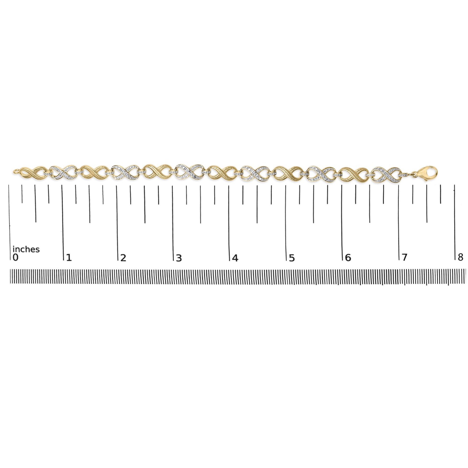 Yellow metal bracelet with alternating infinity shapes, some pave set with white round gemstones, shown flat on a ruler, top-down angle.