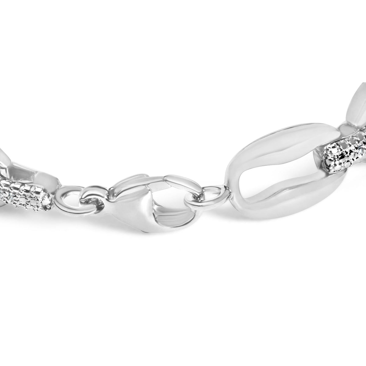 Close-up angled view of a white metal bracelet featuring large oval links interspersed with smaller links set with round white gemstones in a pave setting.