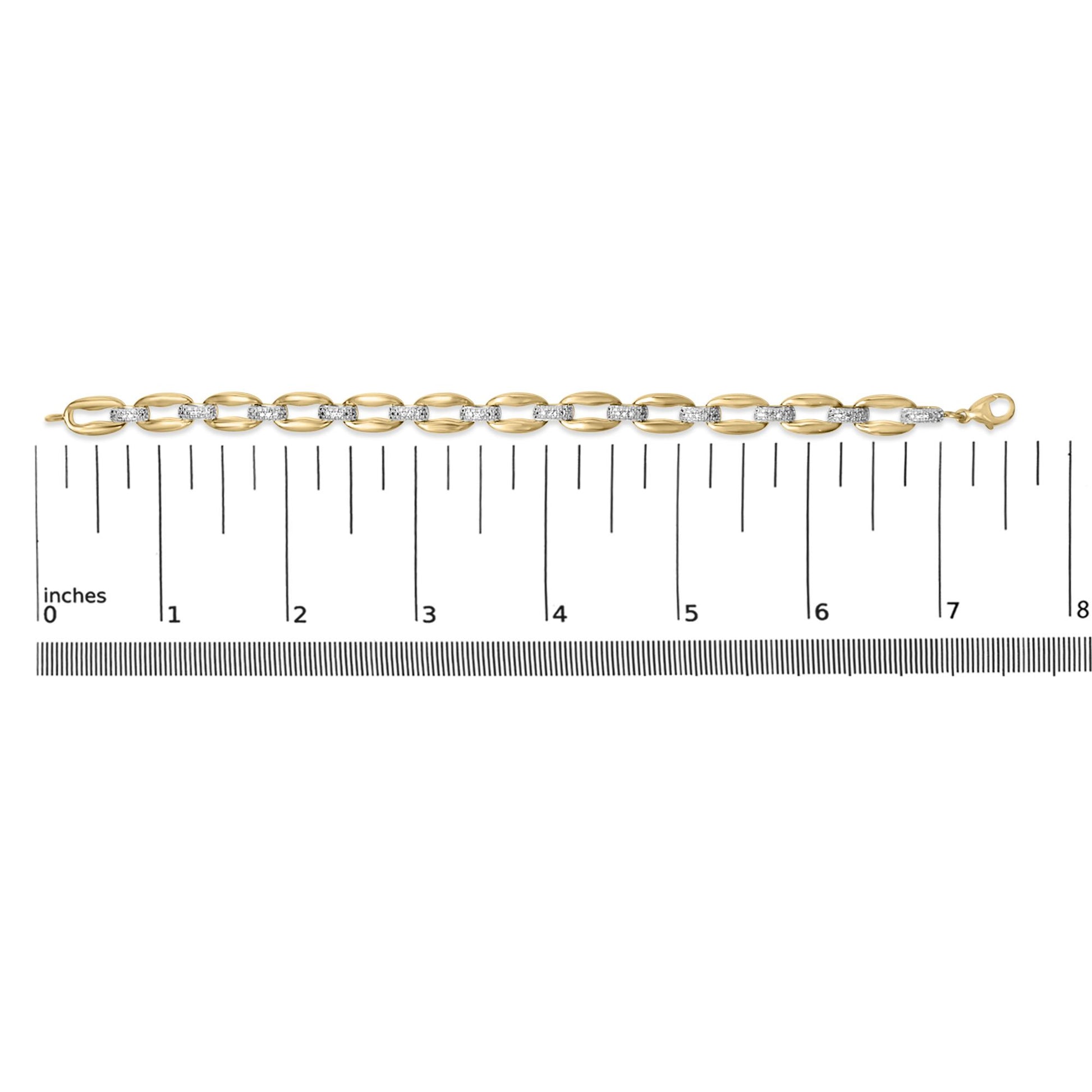 Yellow metal bracelet with alternating smooth oval links and links set with white gemstones in pave setting, shown flat on a ruler, top-down view.