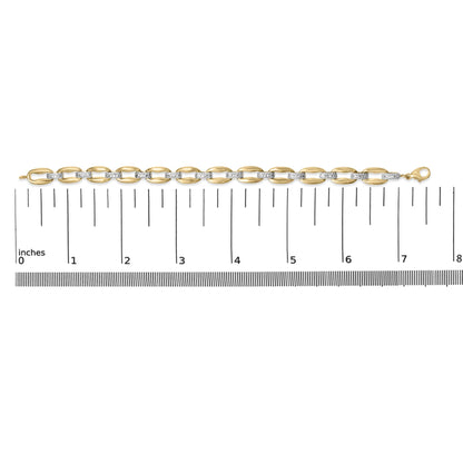 Yellow metal bracelet with alternating smooth oval links and links set with white gemstones in pave setting, shown flat on a ruler, top-down view.