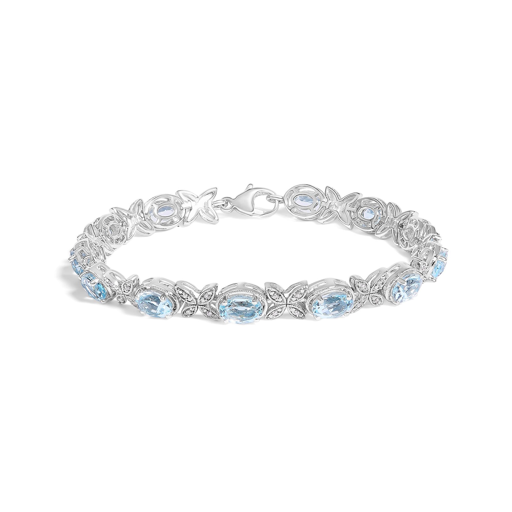 White metal bracelet with alternating oval blue gemstones and small round white gemstones in pave setting, shown from a front angled perspective.