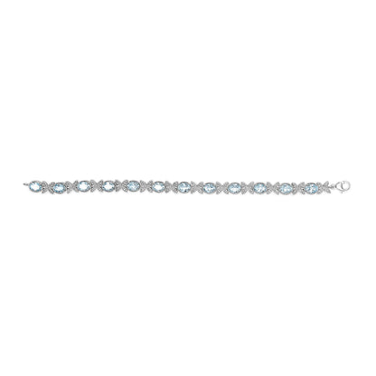 White metal bracelet with alternating oval blue gemstones and clusters of small round white gemstones, shown in a flat horizontal angle.