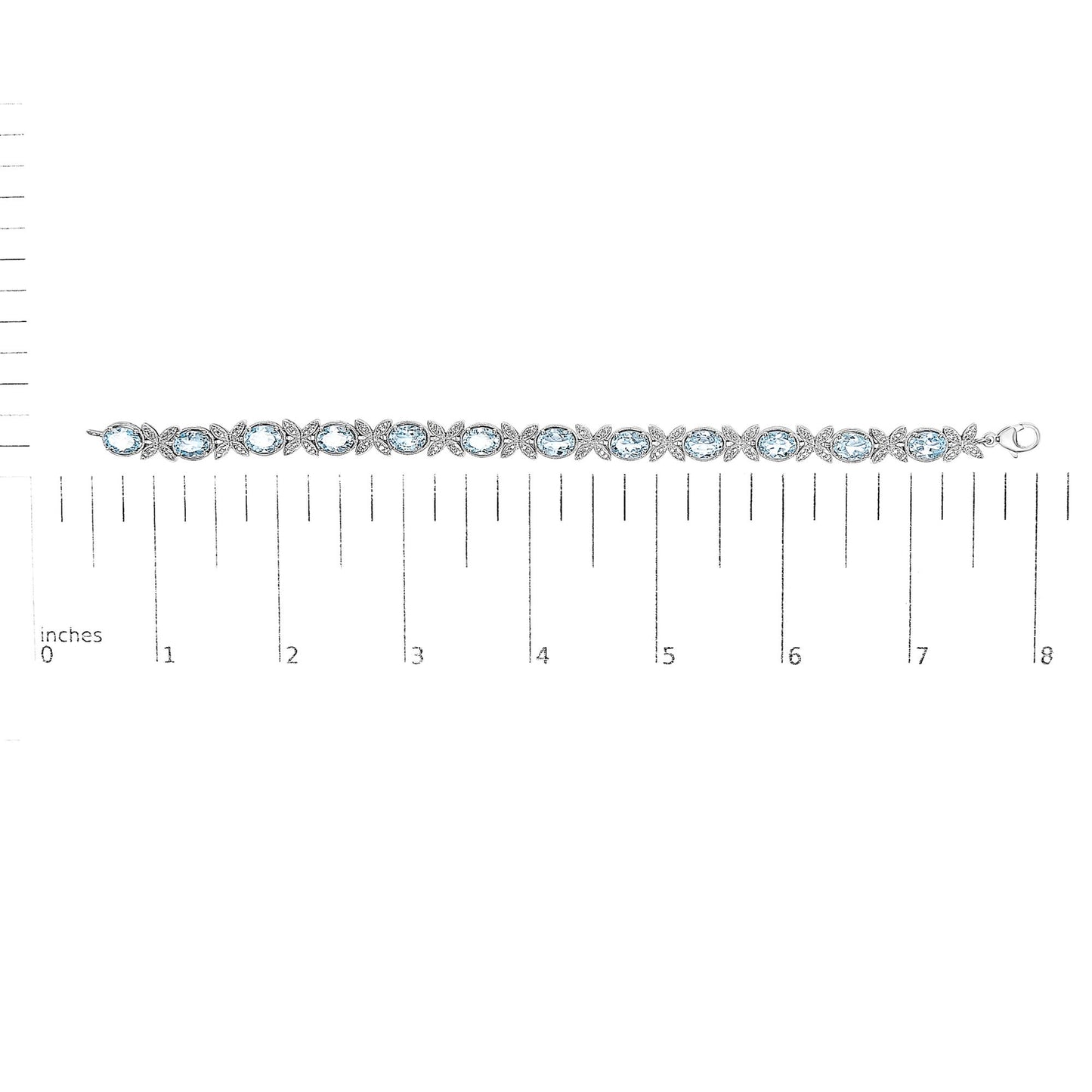 White metal bracelet with alternating oval blue gemstones and round white gemstones in pave setting, laid flat on a ruler for size reference, top-down view.