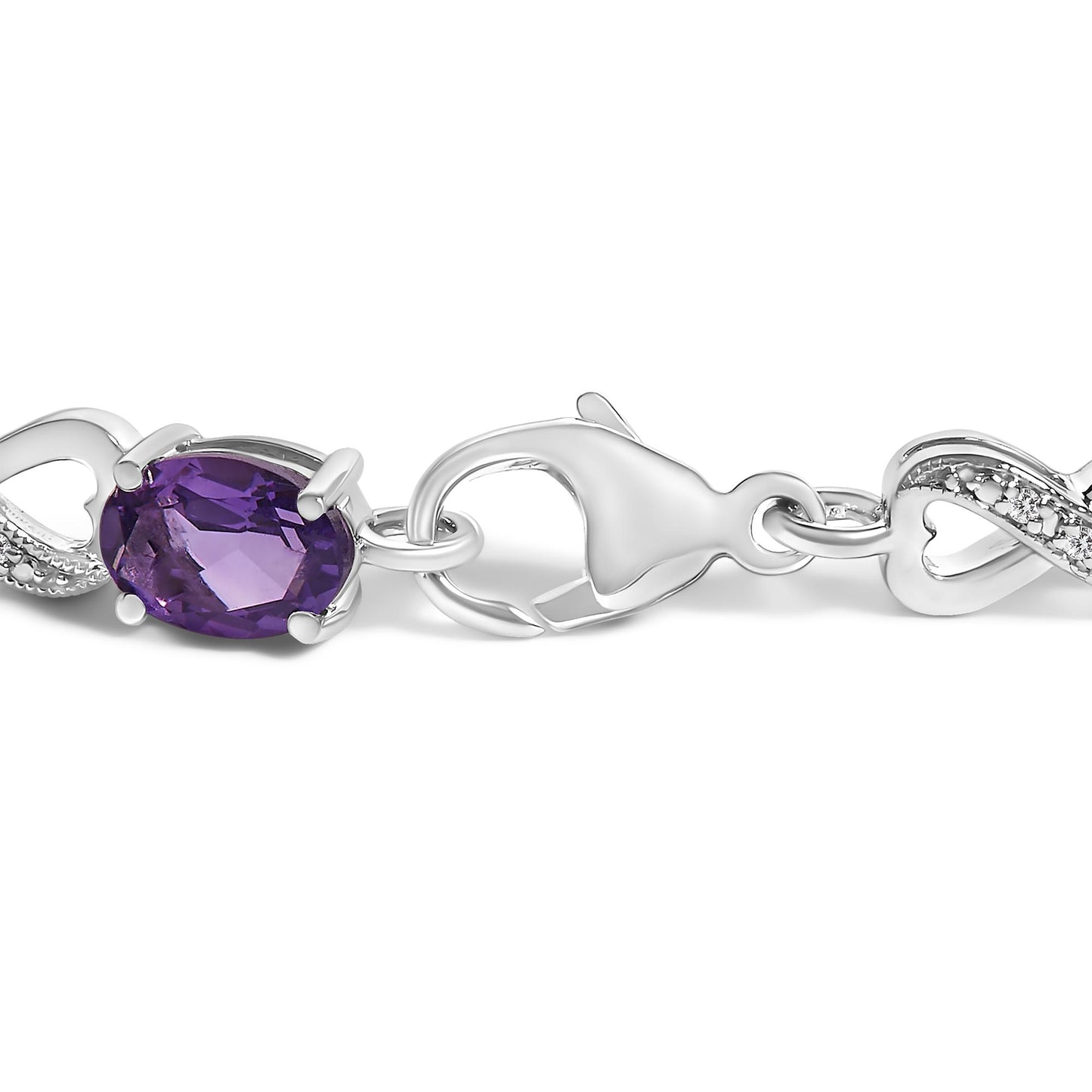 Close-up side angle of a white metal bracelet clasp featuring an oval purple gemstone in prong setting and adjacent white round gemstones with prong setting.
