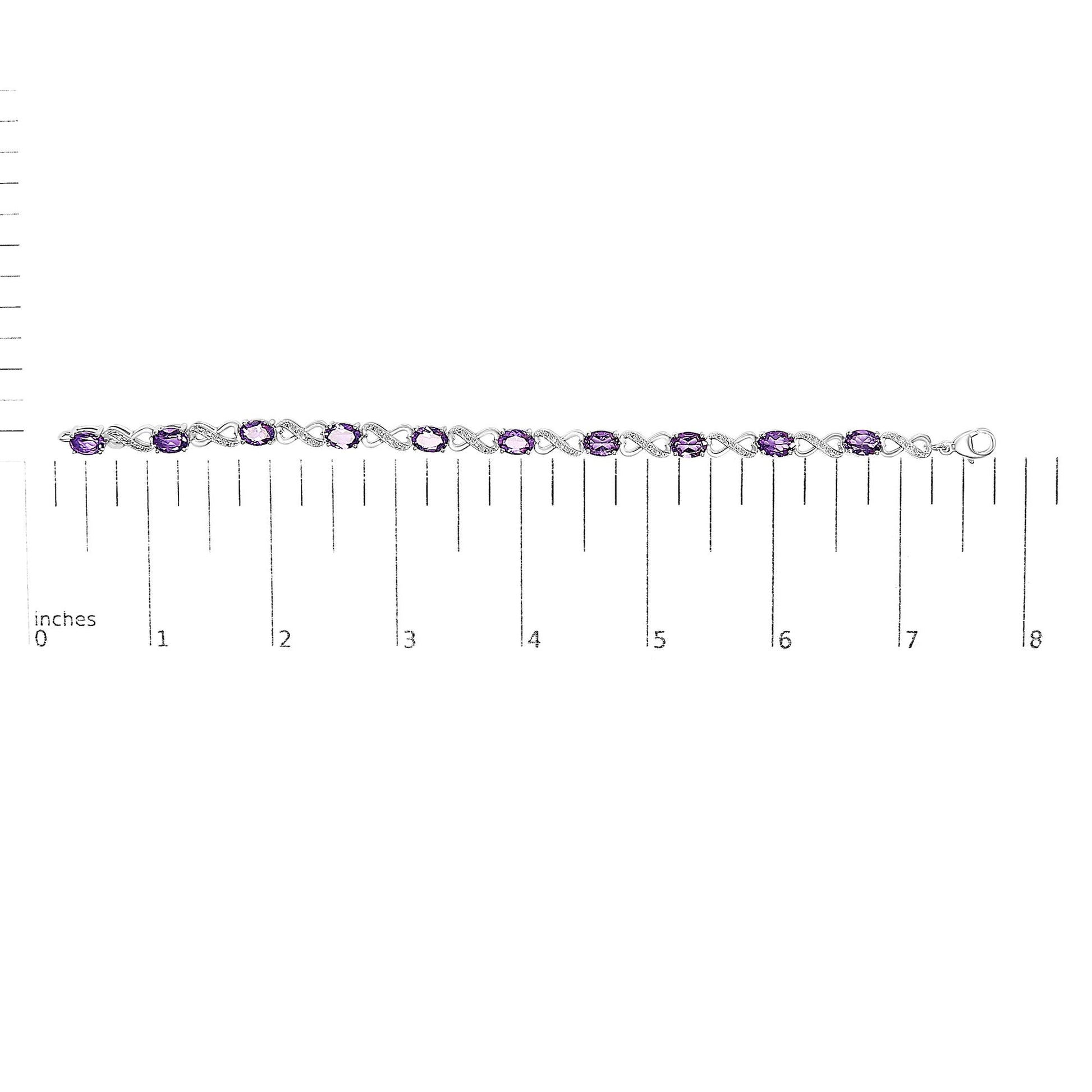 White metal bracelet with oval purple gemstones and round white gemstones in prong settings, displayed flat on a ruler for size reference, shown from top-down angle.