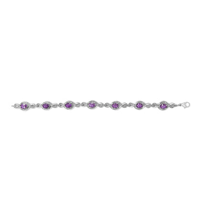 White metal bracelet with alternating oval purple gemstones and small round white gemstones in prong settings, shown in a top-down view.