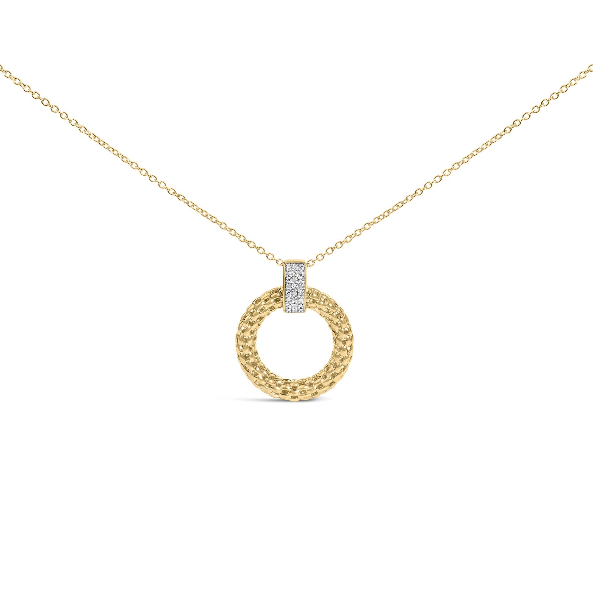 Close-up front view of a yellow metal necklace with a circular pendant featuring a textured design and a vertical bar set with small white gemstones.