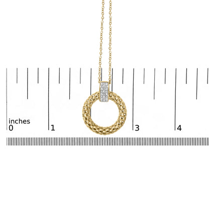 Front close-up of gold vermeil pendant showing braided circular ring and micro-pave diamond bar on inch ruler for scale