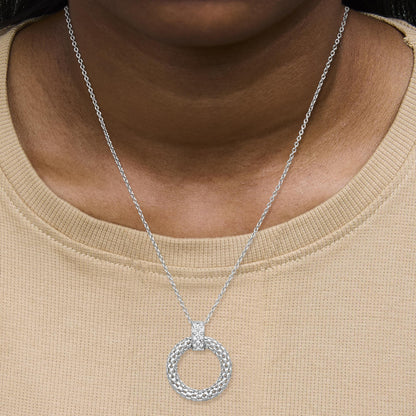 White metal necklace with a circular pendant featuring micro-pave white gemstones, shown worn on a model from the front angle.