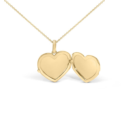 Close-up front angle of a yellow heart-shaped locket necklace open to show inside, suspended from a delicate yellow chain, no gemstones visible.