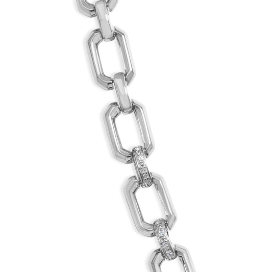 Close-up front angle of a white metal necklace featuring elongated rectangular links, some of which are pavé set with small white gemstones.