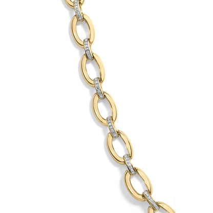 Close-up angled view of a yellow metal necklace featuring oval links connected by smaller links paved with white round gemstones.