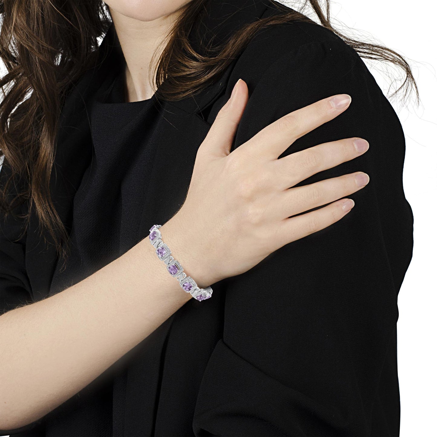White metal bracelet with cushion-shaped purple gemstones and round white gemstones in pave settings, shown on a model's wrist from a side angle.