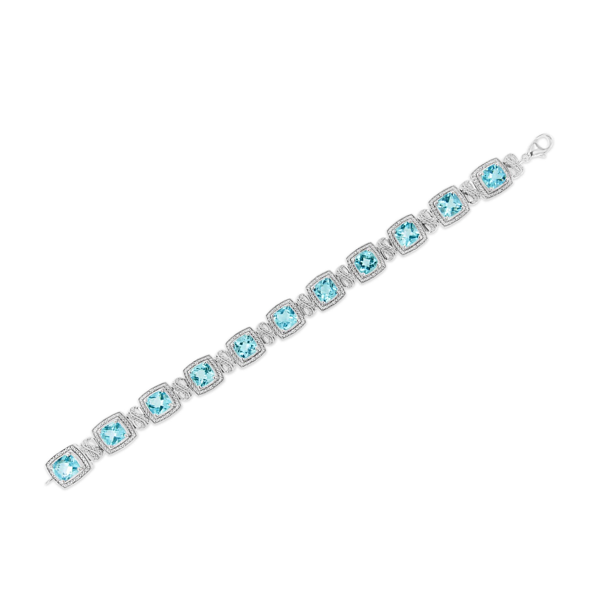 White bracelet with cushion-shaped blue gemstones in prong settings, alternating with small round white gemstones in pave settings, shown flat on white background from an angled top view.