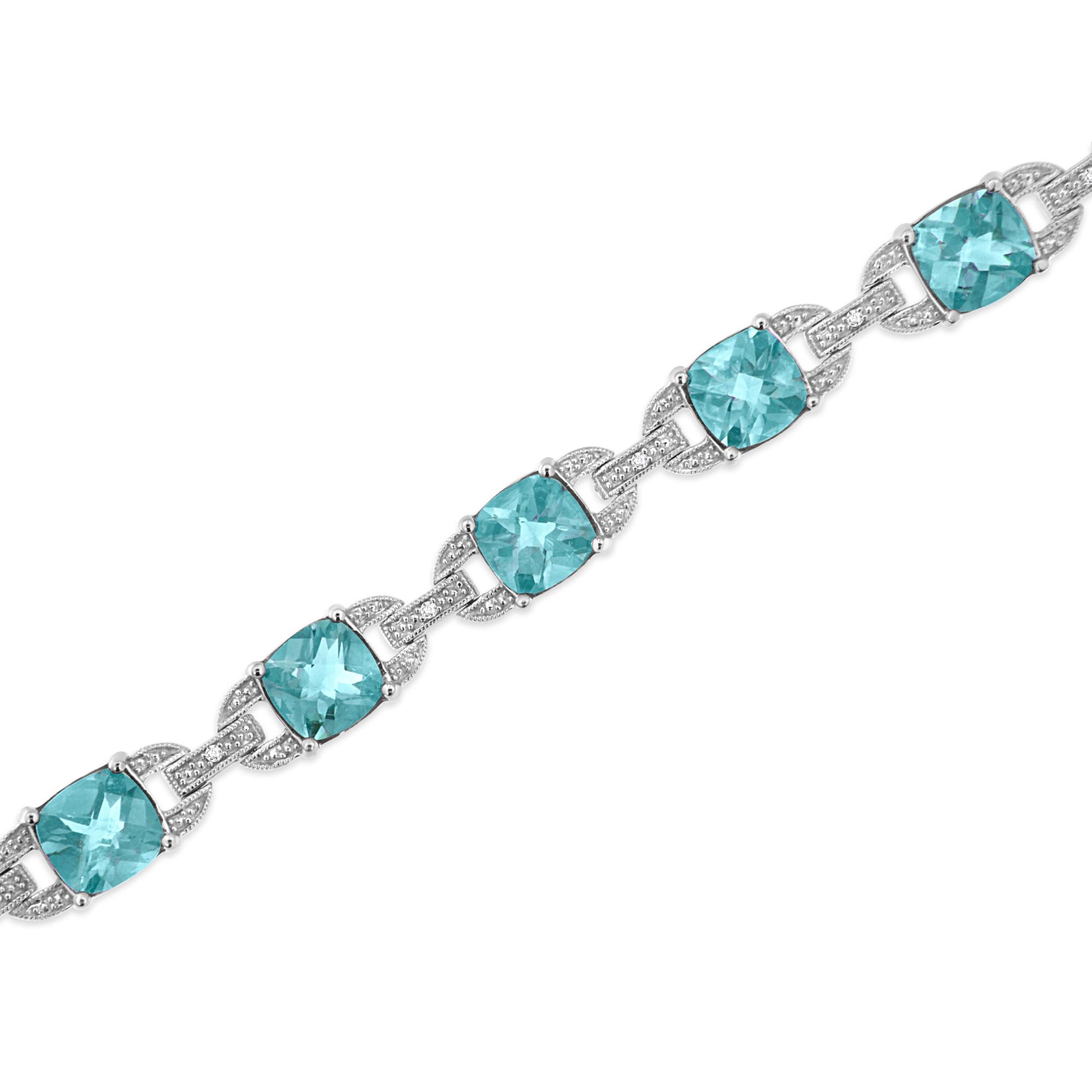 White metal bracelet with cushion-shaped blue gemstones and round white gemstones in prong settings, shown in a diagonal close-up view.