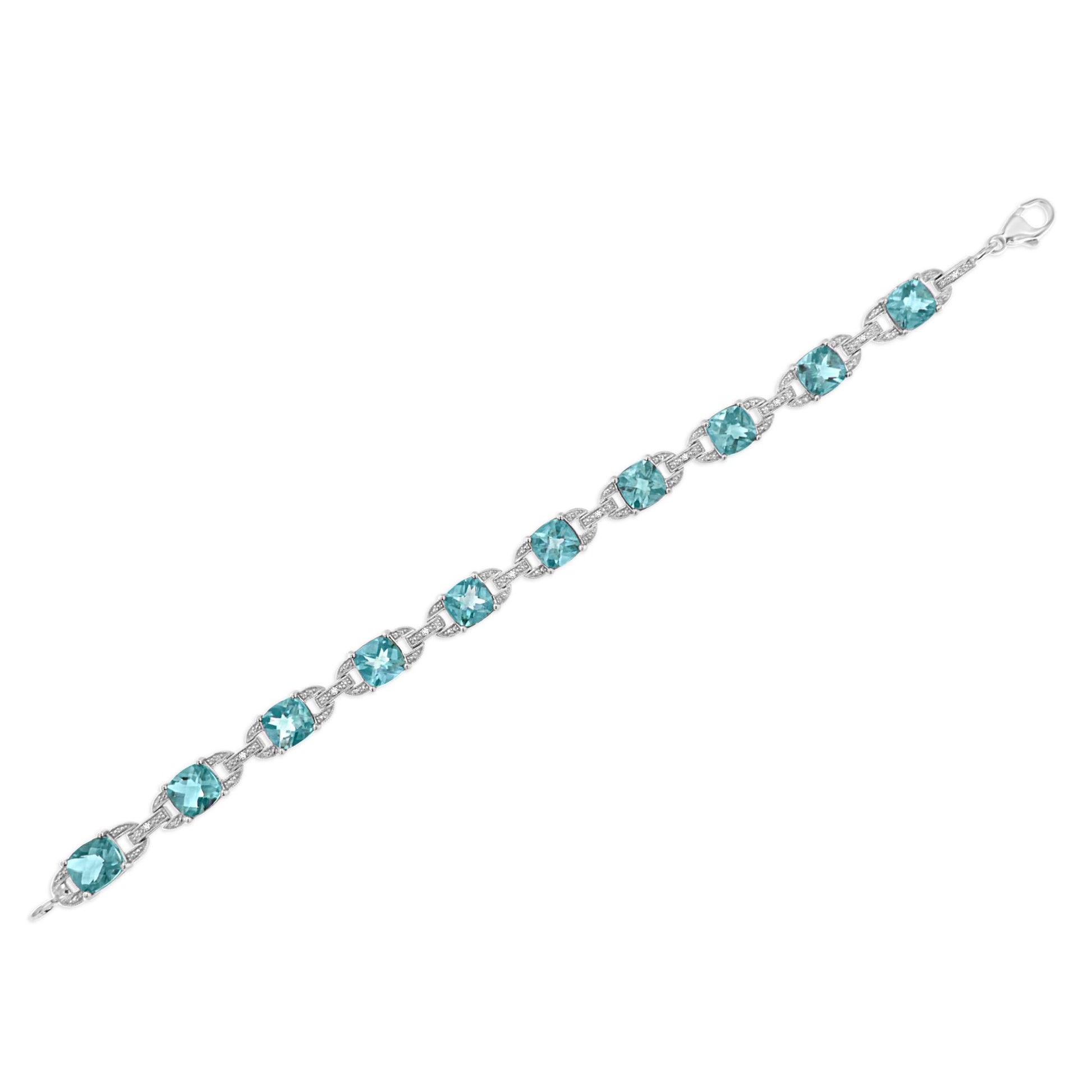 White metal bracelet with blue cushion-shaped gemstones and small round white gemstones in prong settings, shown flat from a top angle.