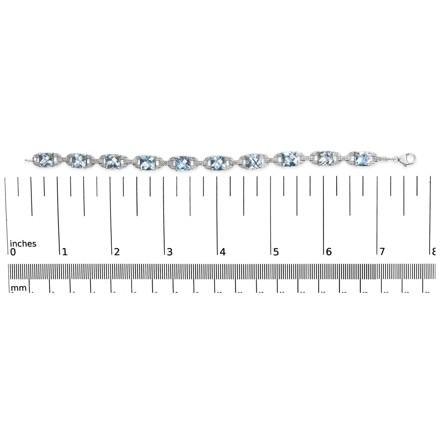 Close-up shot of a white metal bracelet with alternating round white gemstones and cushion-shaped blue gemstones set in prong settings, displayed on a ruler for size reference.