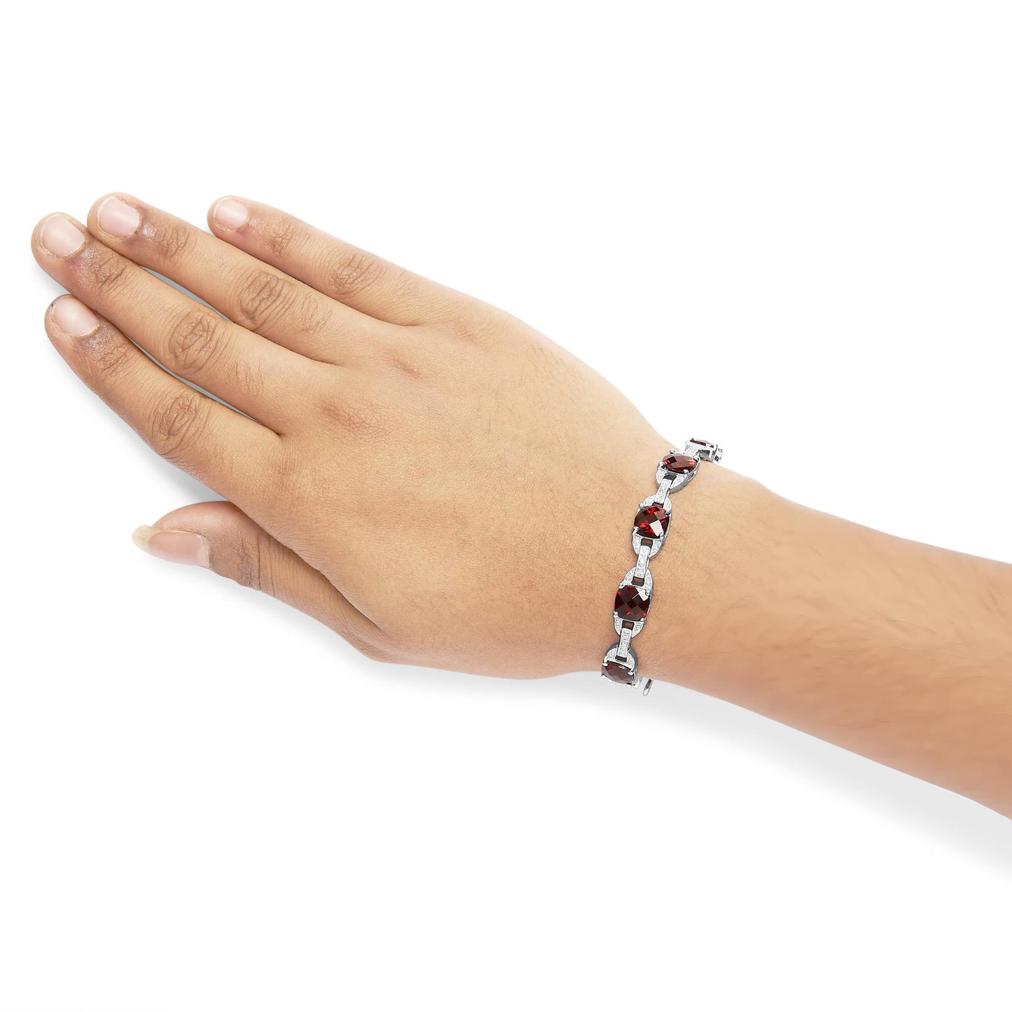 White metal bracelet with alternating red cushion-shaped gemstones and round white gemstones in prong settings, shown on a model's wrist from a top angle.