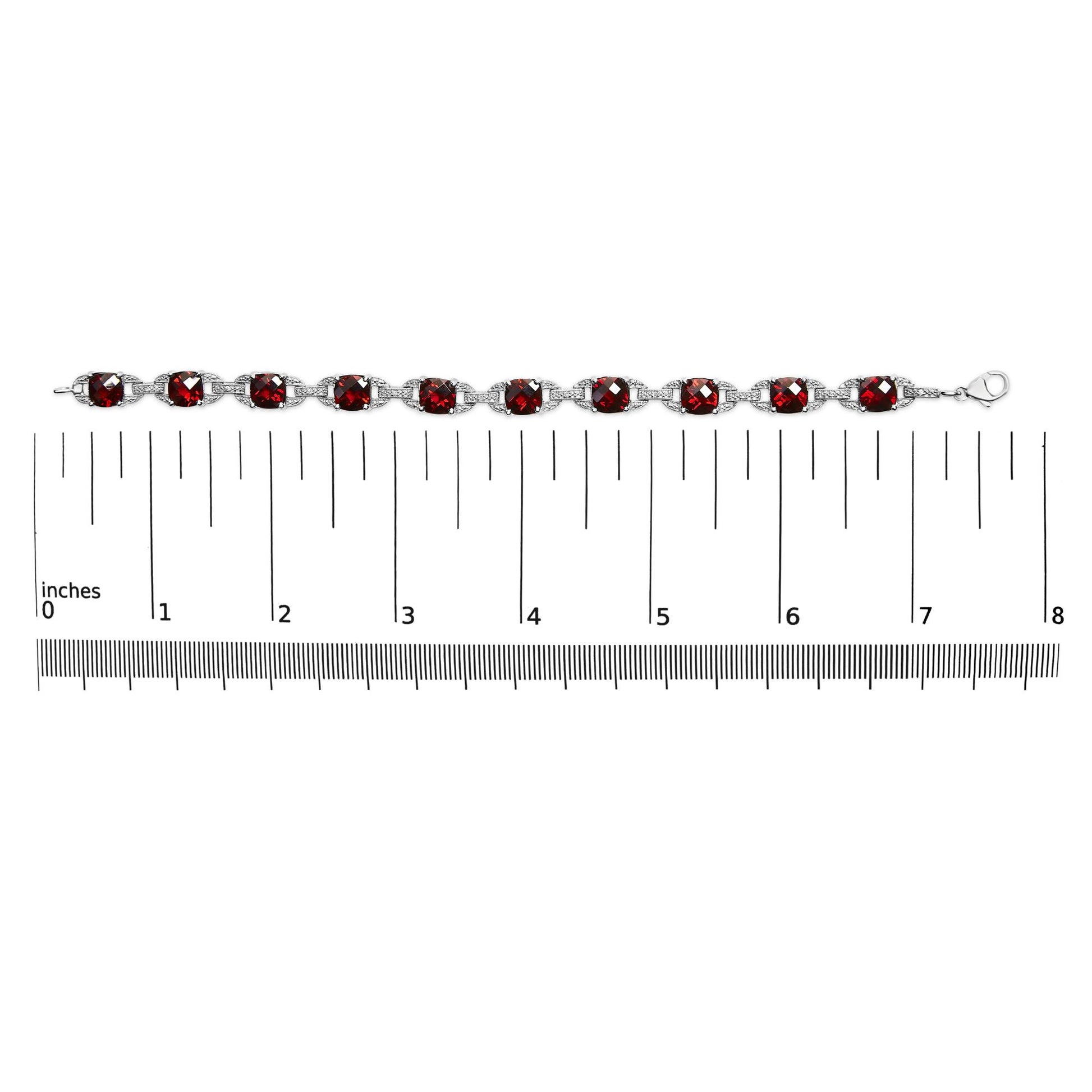 White metal bracelet with alternating round white gemstones and cushion-shaped red gemstones in prong settings, displayed flat on a ruler for size reference, top-down view.