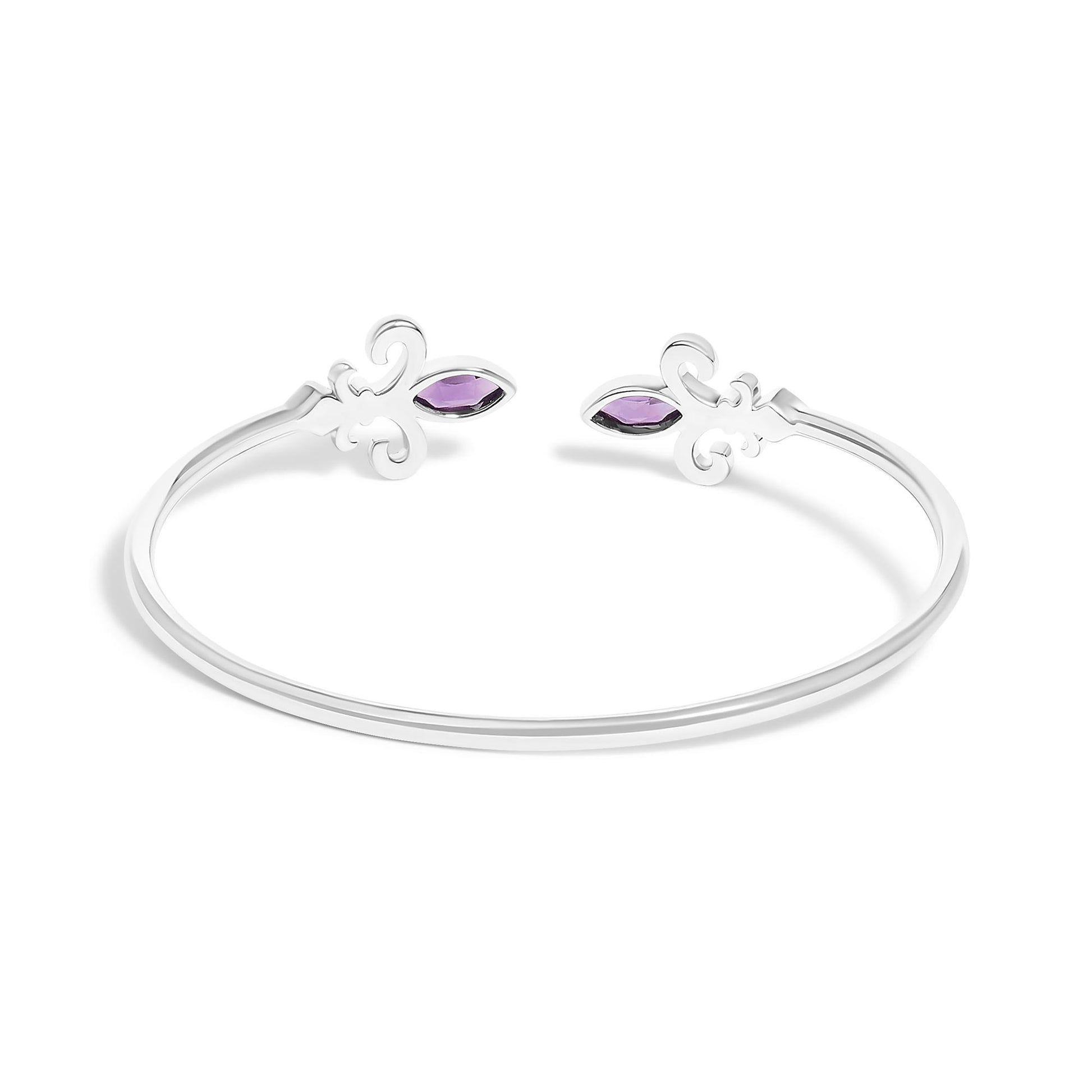 White metal open bracelet with decorative swirl ends, each featuring a purple marquise-shaped gemstone and surrounding small white round gemstones in pave setting, shown angled from above.